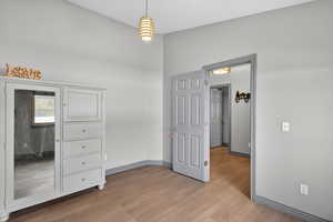 Unfurnished bedroom featuring light wood-type flooring and baseboards