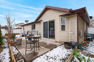 Snow covered property with a patio area