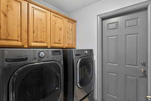 Laundry room with independent washer and dryer and cabinet space