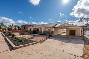 Ranch-style home with a carport, driveway, brick siding, board and batten siding, and a standing seam roof