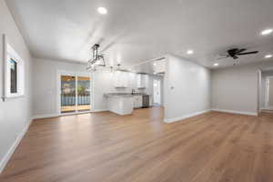 Unfurnished living room with ceiling fan, light wood finished floors, recessed lighting, and a textured ceiling