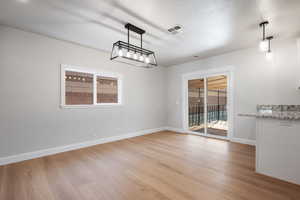 Unfurnished dining area with light wood-type flooring and baseboards