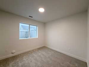 Carpeted empty room featuring baseboards