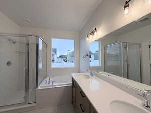 Full bath featuring double vanity, a stall shower, and a garden tub