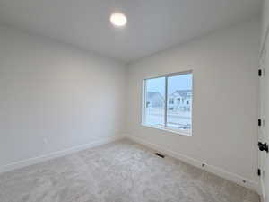 Carpeted empty room with baseboards
