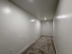 Spare room with baseboards and light carpet