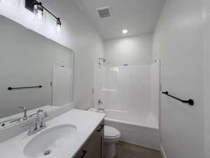 Bathroom with vanity,  shower combination, and dark wood-type flooring