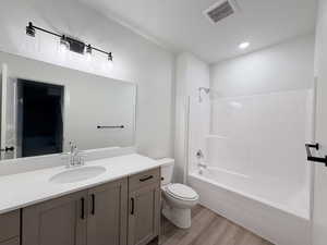 Bathroom with vanity, light wood finished floors, and shower / tub combination