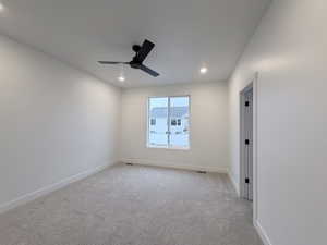 Spare room featuring light colored carpet, ceiling fan, and recessed lighting