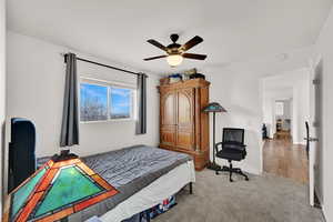 Bedroom with light colored carpet and ceiling fan