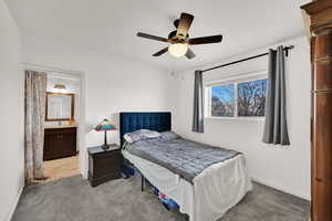 Bedroom with a ceiling fan, carpet flooring, and ensuite bath