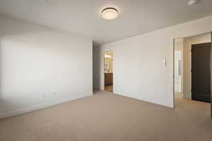 Unfurnished bedroom featuring carpet floors and ensuite bath