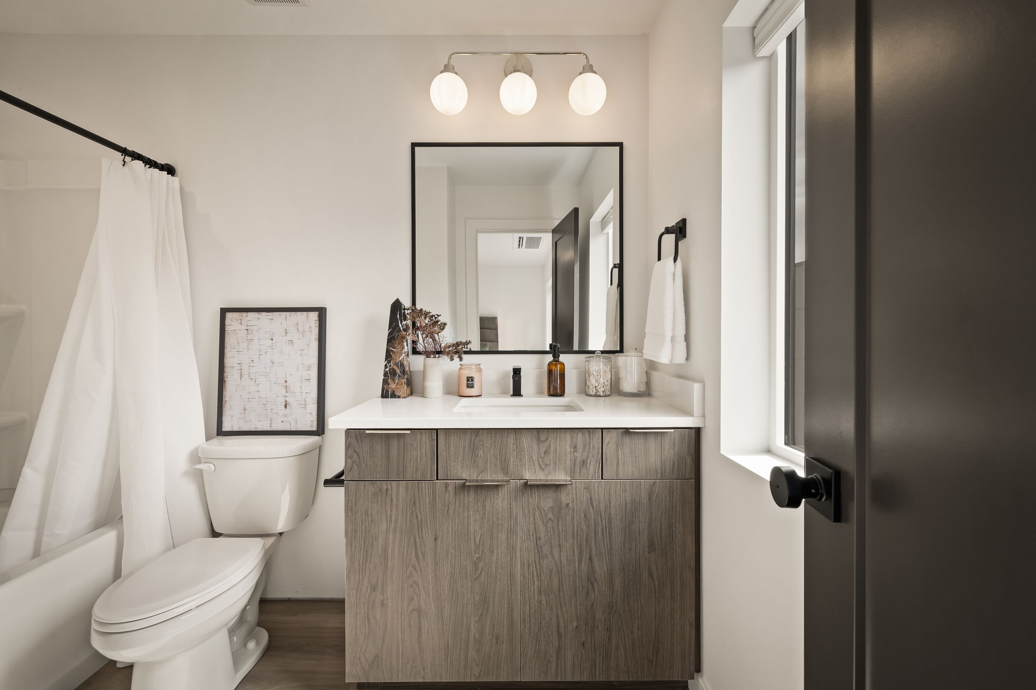 Full bathroom featuring vanity, shower / tub combo, and dark wood-type flooring