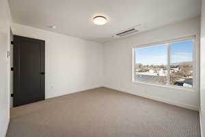 Carpeted empty room with baseboards and cooling unit