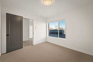 Unfurnished bedroom with carpet and baseboards