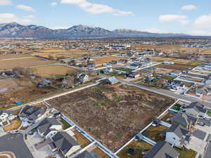 Aerial view of property and surrounding area featuring nearby suburban area and a mountain backdrop