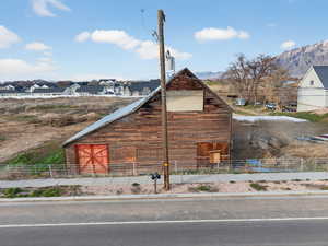 View of home's exterior with a barn, an outdoor structure, and a residential view