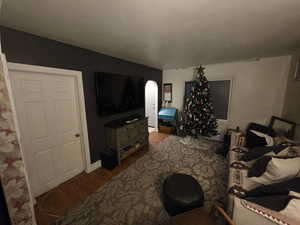 Living area with wood finished floors and arched walkways