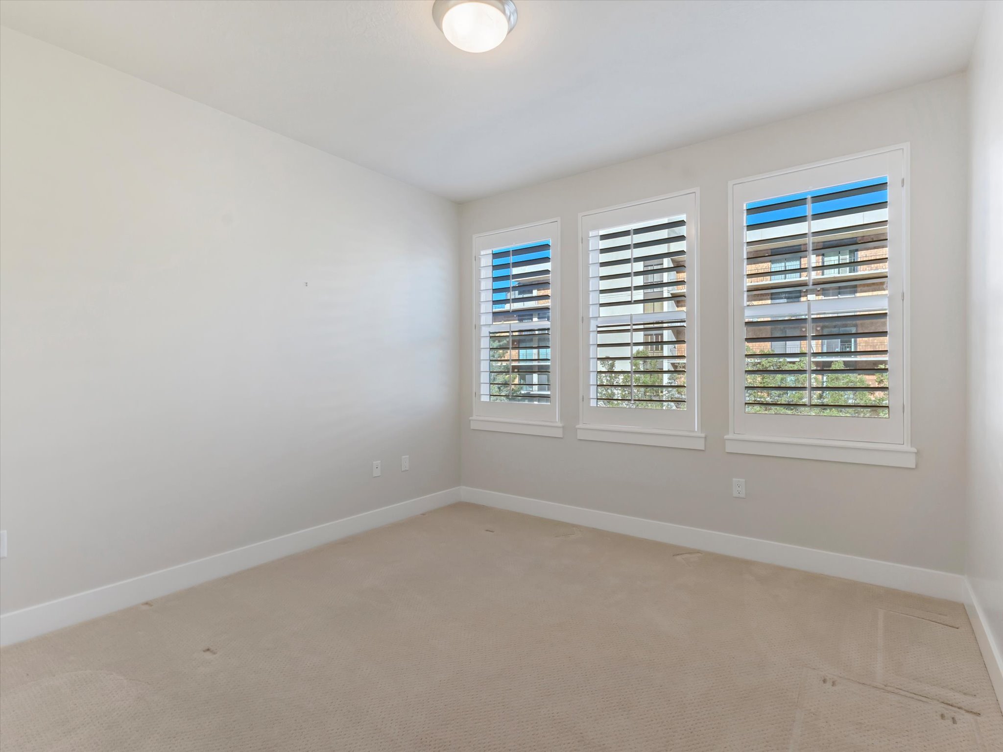Spare room featuring baseboards and light carpet