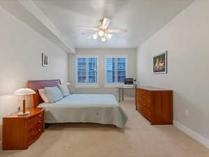 Carpeted bedroom featuring baseboards and a ceiling fan