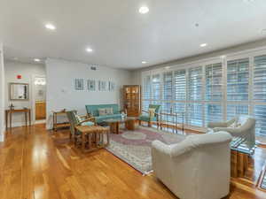 Living area with light wood-type flooring and recessed lighting.