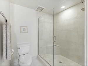 Master bathroom featuring a shower stall, european doors, recessed lighting, and tile patterned floors.