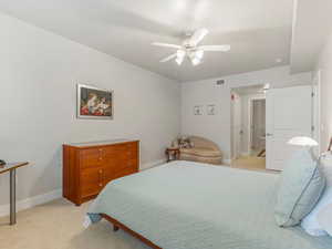 Bedroom with light carpet and a ceiling fan