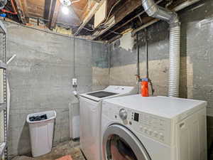 Laundry area featuring independent washer and dryer and concrete floors