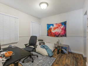Office area with dark wood-style flooring and baseboards