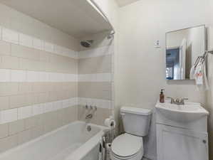 Full bath featuring vanity, shower / tub combination, and a textured wall