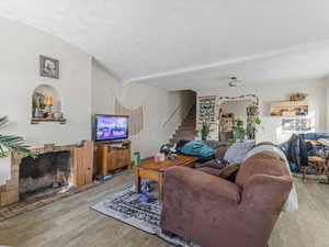 Living room featuring light wood-style flooring and a fireplace with raised hearth