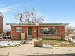 Bungalow-style home with brick siding and a porch