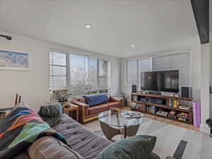 Living area with healthy amount of natural light, light wood-style flooring, recessed lighting, and cooling unit