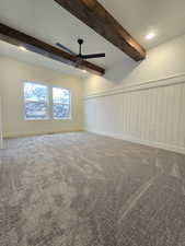 Empty room with carpet floors, a ceiling fan, beam ceiling, recessed lighting, and wainscoting
