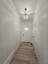 Doorway to outside with wood finished floors and baseboards