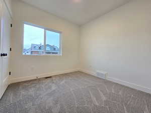 Carpeted spare room with baseboards