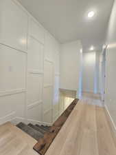 Corridor with light wood-style floors and a textured ceiling