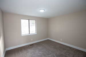 Main level bedroom featuring carpet floors and baseboards