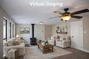 Virtually Staged Living room featuring a wood stove, carpet flooring, and a ceiling fan