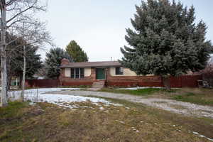 Single story home with brick siding and a circular driveway