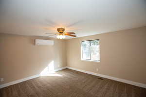 Carpeted master bedroom featuring a mini split for heating / cooling and a ceiling fan