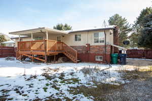 Back of property featuring brick siding and a covered wooden deck