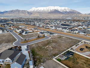 Aerial view of property and surrounding area featuring nearby suburban area and a mountain backdrop