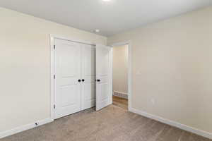 Unfurnished bedroom featuring carpet floors and a closet