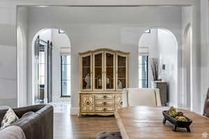Dining area featuring arched walkways and dark wood-style flooring