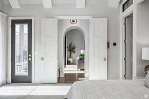 Bedroom featuring arched walkways and access to outside