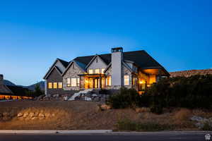 View of front of home featuring stone siding and a balcony