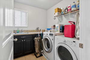Laundry room with light tile patterned floors and separate washer and dryer