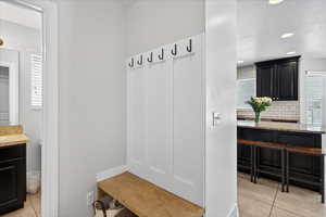 Mudroom with light tile patterned flooring, recessed lighting, and a textured ceiling