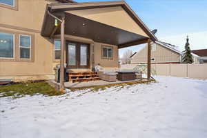 Snow covered property entrance featuring an outdoor hangout area, a patio, stucco siding, and french doors